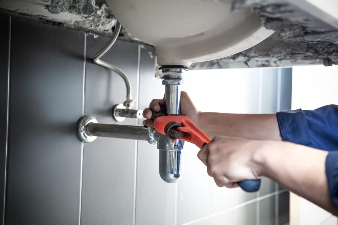 Plumber,Uses,Wrench,To,Repair,Water,Pipe,Under,Sink,There